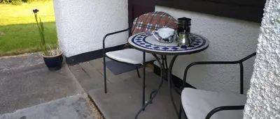 a small table with a cup of coffee on a patio at Aquila Retreats in Comrie