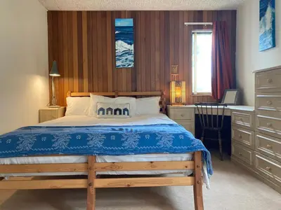 a bedroom with a large bed with a desk and a window at Aquila Retreats in Comrie