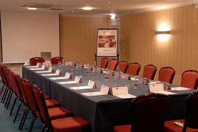 a long table in a room with red chairs at Best Western Plus Dunfermline Crossford Keavil House Hotel in Dunfermline