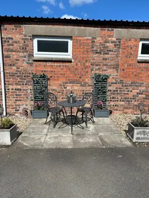 a table and chairs in front of a brick building at Robin's Rest in Auchterarder