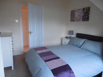 a bedroom with a bed with a striped blanket on it at Robin's Rest in Auchterarder