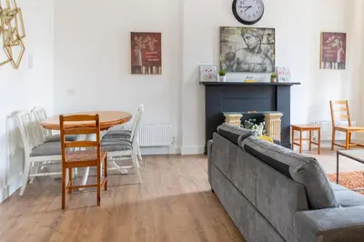 a living room with a couch and a table at Bright High-Ceiling 2BD Flat - Central Edinburgh! in Edinburgh