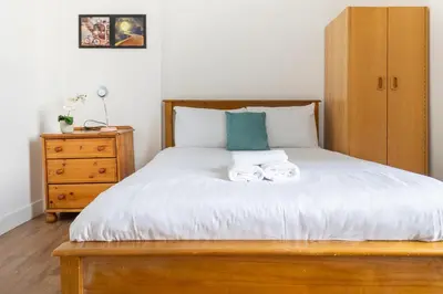 a bedroom with a bed with two towels on it at Bright High-Ceiling 2BD Flat - Central Edinburgh! in Edinburgh