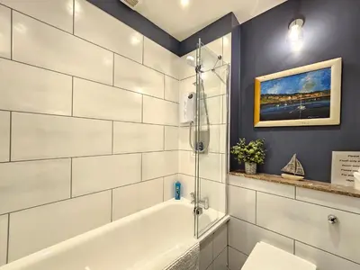 a bathroom with a white tub and a sink at Unique Edinburgh New Town Apartment near Princes Street in Edinburgh