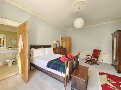 a bedroom with a large bed and a bathroom at Unique Edinburgh New Town Apartment near Princes Street in Edinburgh