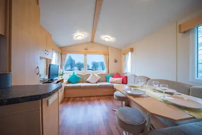a kitchen and living room with a table and a couch at Newton Stewart-Sleeps 6-Pool-Parking-Pet Friendly in Newton Stewart