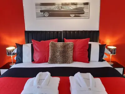 a bedroom with a bed with a car on the wall at Cadillac Kustomz Guest House in Rothesay