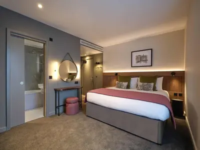 a bedroom with a large bed and a mirror at The Resident Edinburgh in Edinburgh