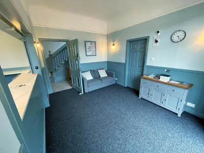 a room with a staircase with a chair and a clock at King's Knoll Hotel in Oban