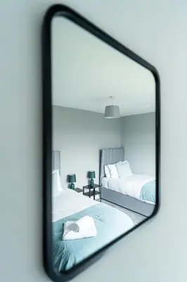 a mirror reflection of a bedroom with two beds at The Bowhouse in Grangemouth