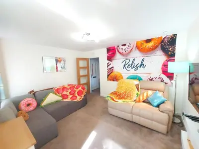 a living room with two couches and a wall with donuts at The Blossom - Largs in Largs