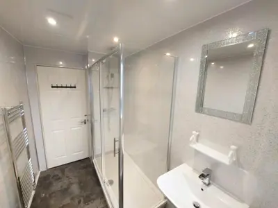 a bathroom with a shower and a sink and a mirror at The Blossom - Largs in Largs