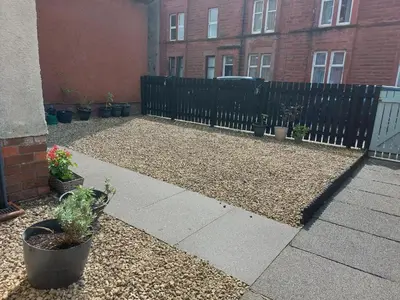 a courtyard with potted plants and a fence at The Blossom - Largs in Largs