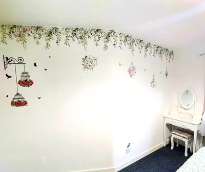 a bedroom with a white wall with flowers and bird cages at The Blossom - Largs in Largs