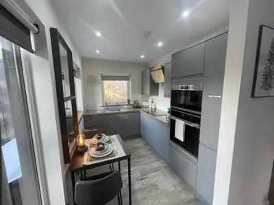 a kitchen with a table and a stove top oven at Mackie lodge in Luss