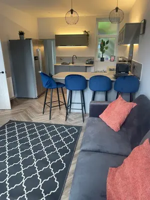 a living room with a couch and a kitchen at Springlea in Oban