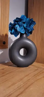 a black vase with a blue flower in it at Ben Vorlich Cottage in Tarbet