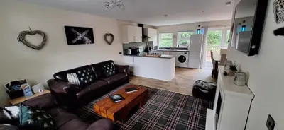 a living room with a couch and a table at Ben Vorlich Cottage in Tarbet