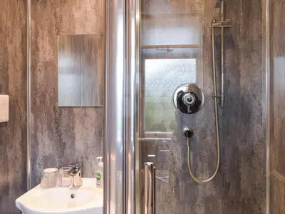 a bathroom with a shower and a sink at Wayside Cottage in Dunoon