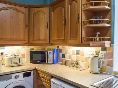 a kitchen with a counter top with a microwave at Wayside Cottage in Dunoon