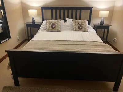 a bedroom with a large bed with two night stands at Wilmar Lodge in Arrochar