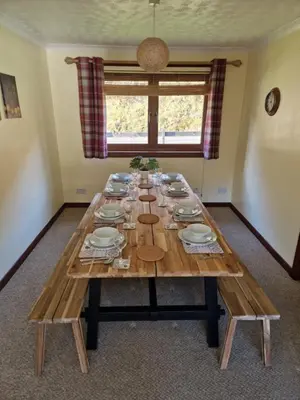 a long wooden table with plates and dishes on it at Wilmar Lodge in Arrochar