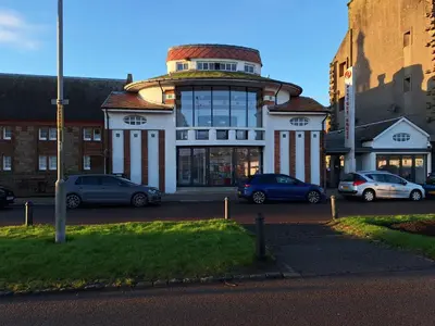 a building with cars parked in a parking lot at Ocean View in Campbeltown