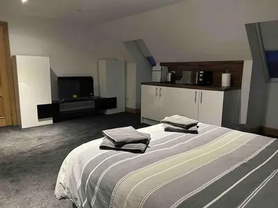 a bedroom with a large bed with two towels on it at 101 Scotia Rooms in South Cobbinshaw