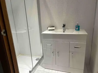 a white bathroom with a sink and a shower at 101 Scotia Rooms in South Cobbinshaw