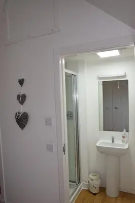 a white bathroom with a sink and a mirror at The Barn at Drumachro in Isle of Gigha