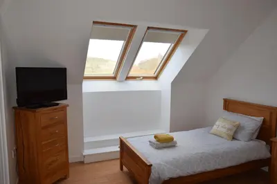 a bedroom with a bed and a tv on a dresser at The Barn at Drumachro in Isle of Gigha