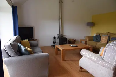 a living room with two chairs and a coffee table at The Byre at Drumachro in Isle of Gigha