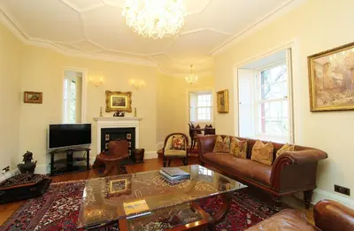 a living room with a couch and a tv at Elegant 3-Bedroom Ramsay Garden Apartment in Edinburgh City Centre in Edinburgh