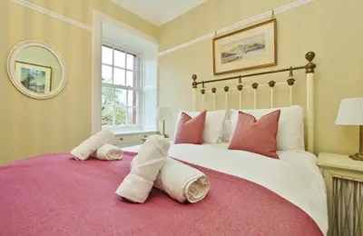 a bedroom with a large bed with towels on it at Elegant 3-Bedroom Ramsay Garden Apartment in Edinburgh City Centre in Edinburgh