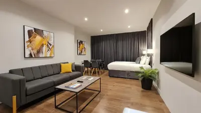 a living room with a couch and a bed at VCity ApartHotels Glasgow Central in Glasgow
