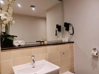 a bathroom with a sink and a mirror at VCity ApartHotels Glasgow Central in Glasgow