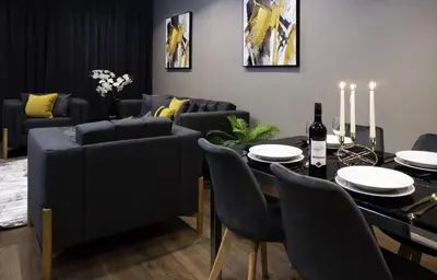 a living room with a table and chairs and a couch at VCity ApartHotels Glasgow Central in Glasgow