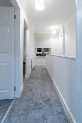 an empty room with white walls and a hallway at Bell Apartment in Airdrie
