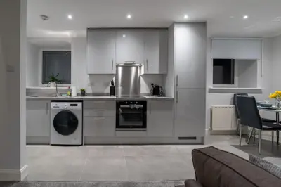 a kitchen with a stove and a dishwasher at Bell Apartment in Airdrie