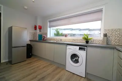 a kitchen with a washing machine and a window at Signature - Glen Garry House in East Kilbride