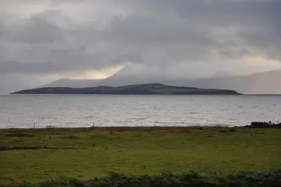 a large body of water with a mountain in the background at Beautiful spacious old schoolhouse with stunning sea views and beach nearby in Port Bannatyne