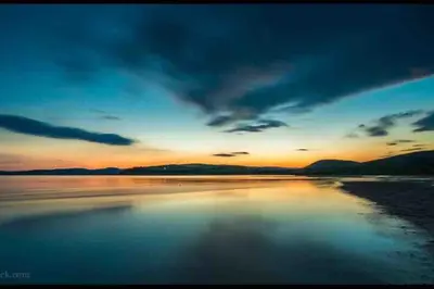 a sunset over a body of water at Beautiful spacious old schoolhouse with stunning sea views and beach nearby in Port Bannatyne