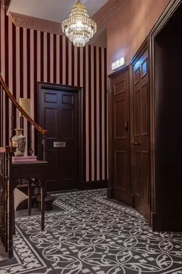 a hallway with a staircase and a chandelier at Eleven Stafford Street Townhouse in Edinburgh