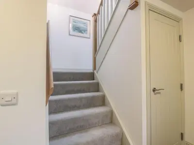 a staircase in a house with grey carpeted stairs at Thorneydyke Cottage in Stirling