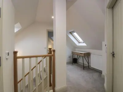 an attic hallway with a skylight and a desk at Thorneydyke Cottage in Stirling