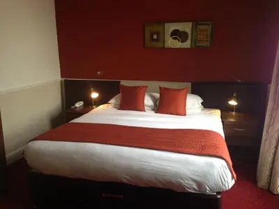 a bedroom with a large bed with red walls at Aberdour Hotel, Stables Rooms & Beer Garden in Aberdour