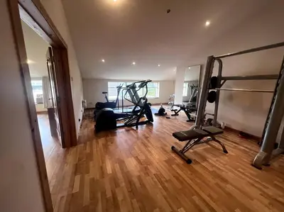 a gym with several tread machines in a room at Langside apartments in Newhouse