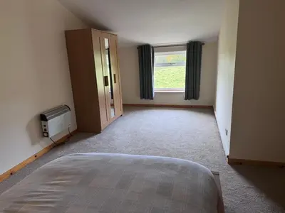 an empty room with a bed and a window at Langside apartments in Newhouse