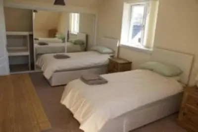 a bedroom with two beds and a mirror at Glenview Salen in Salen