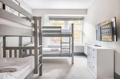 a bedroom with two bunk beds and a desk at Immaculate 3 Bed Apartment with Private Entrance in Inverleith in Edinburgh